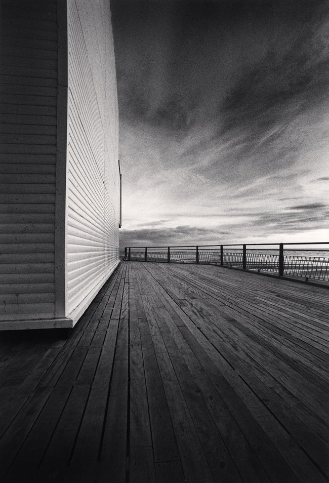 A black and white photo of an empty pier.