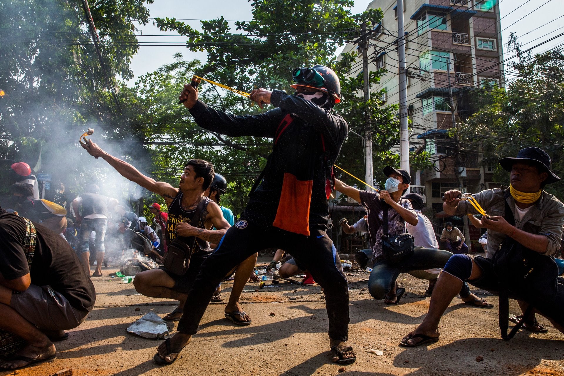 A photographer who is being kept anonymous to protect their safety won the Singles category for this photo of protesters using slingshots and other improvised weapons to fight security forces in Myanmar.