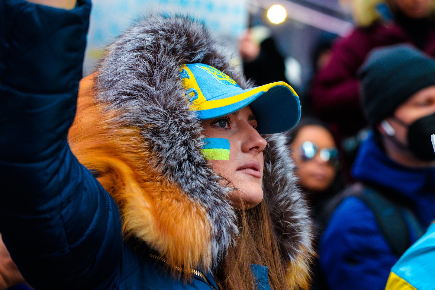 Portrait of a young women wearing face paint showing the Ukraine flag.