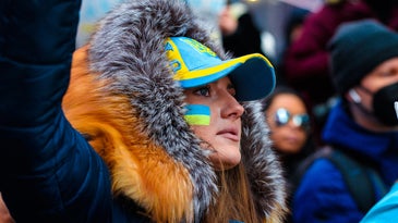 Portrait of a young women wearing face paint showing the Ukraine flag.