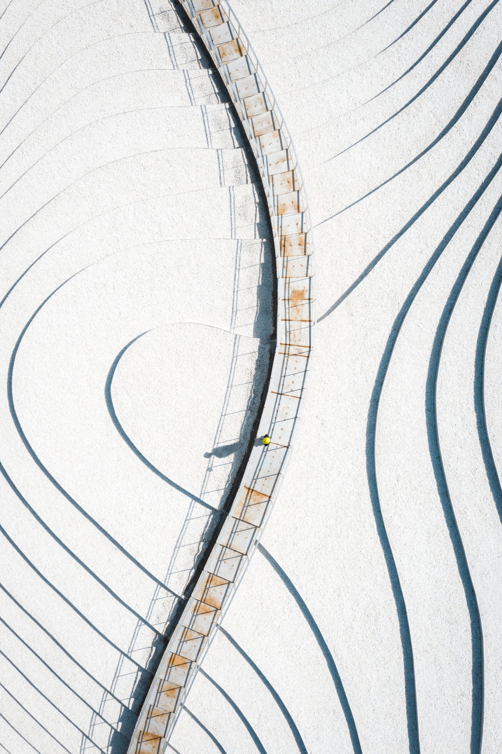 An abstract shot of a walkway over a snow covered field.