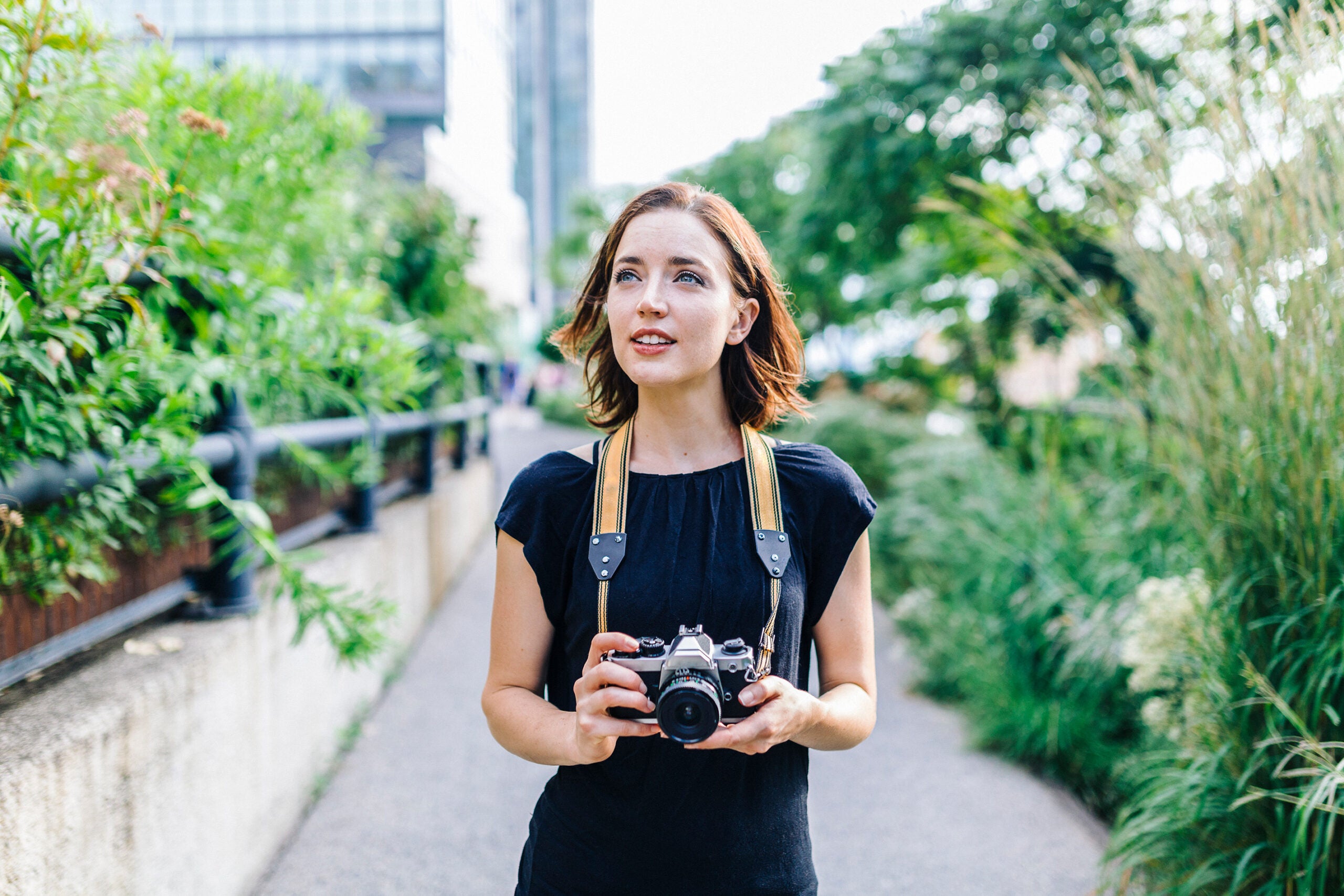 A young women holding a film camera.