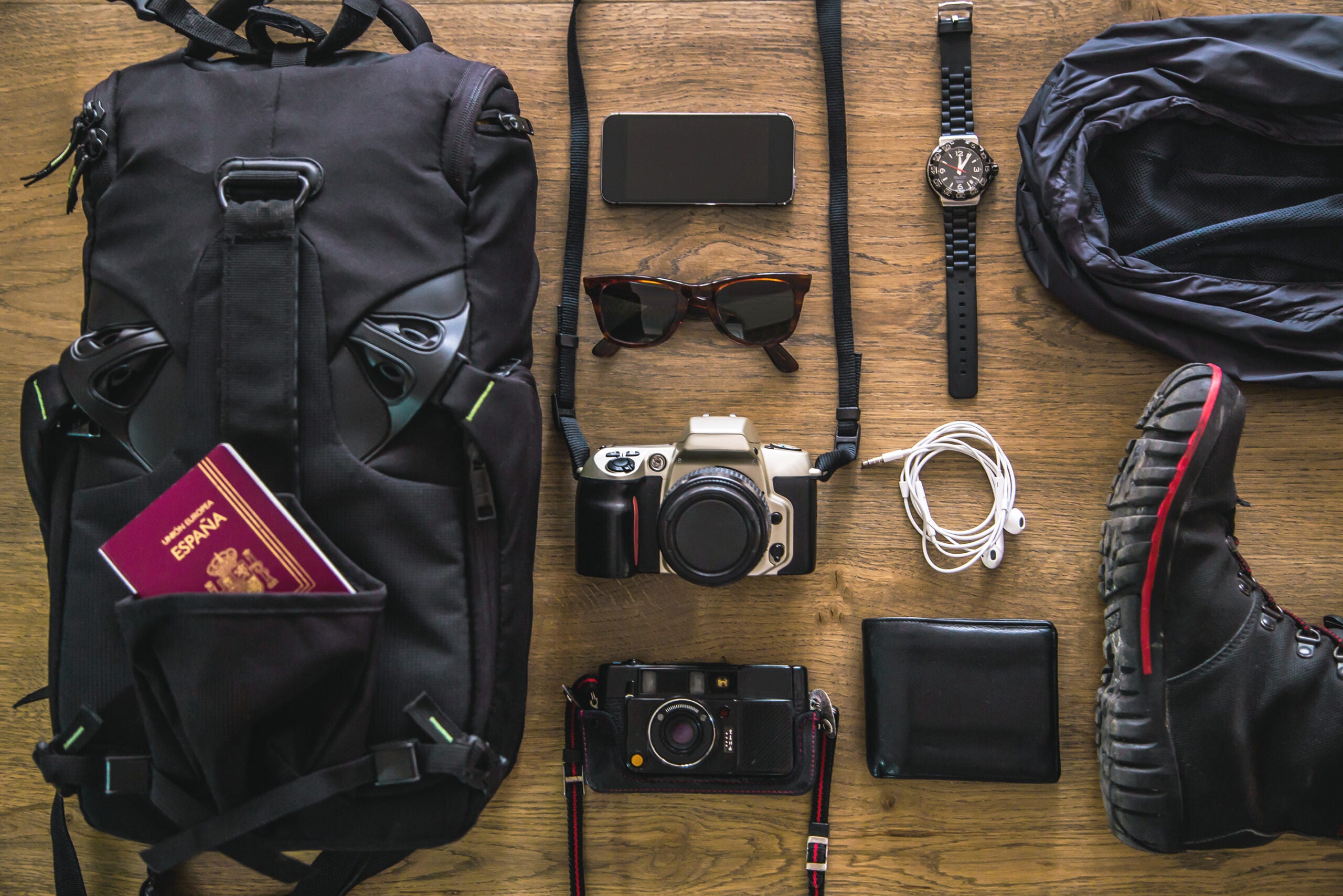 Travel gear laid out on the floor, including a film camera