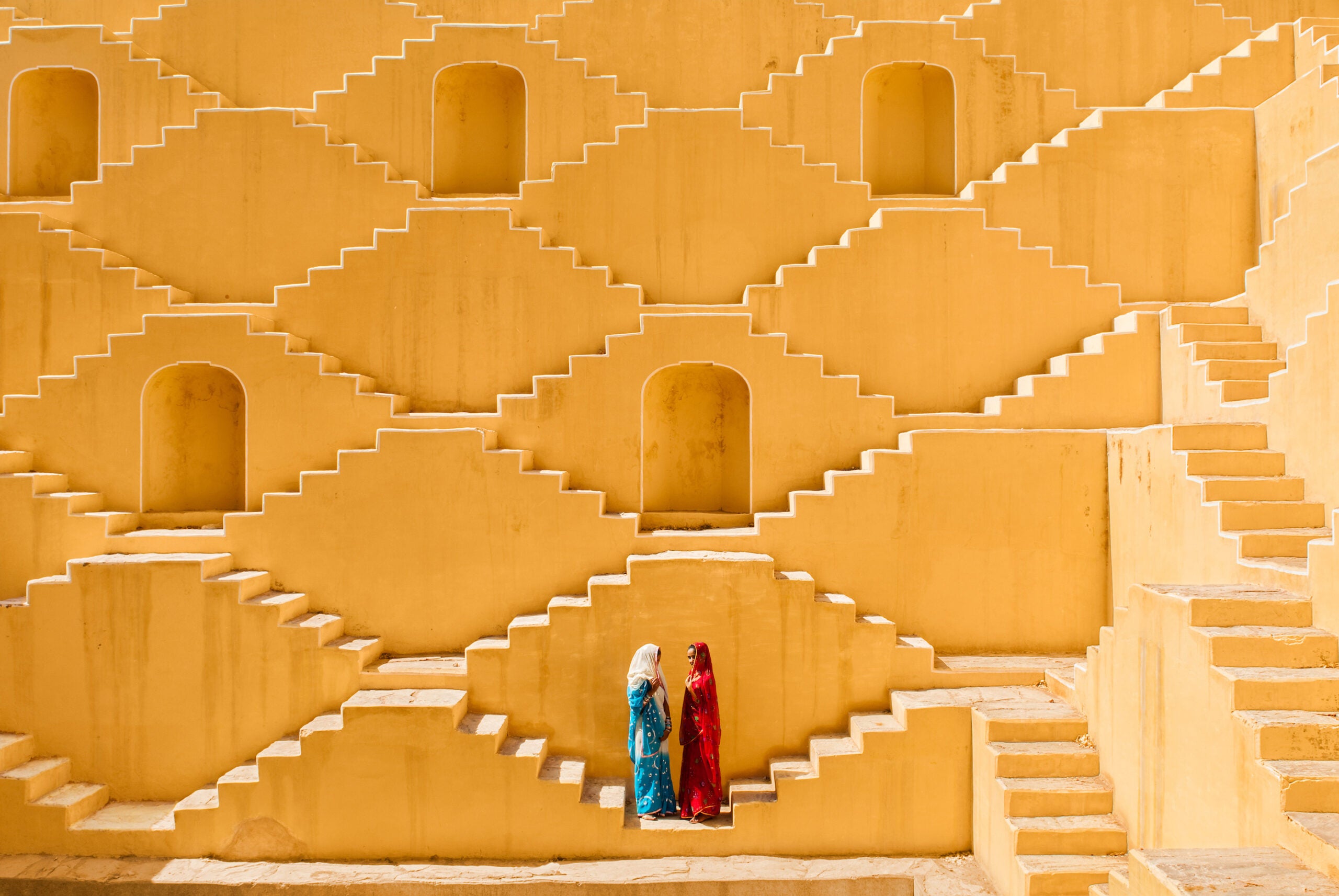 In this photo Manisha and Jasmin Singh pause in the Baoli, an ancient step well in a village near the city of Jaipur outside of Indiaâs Thar desert.