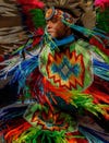 A member of an indigenous dance troop wears traditional feathers and dress for a performance