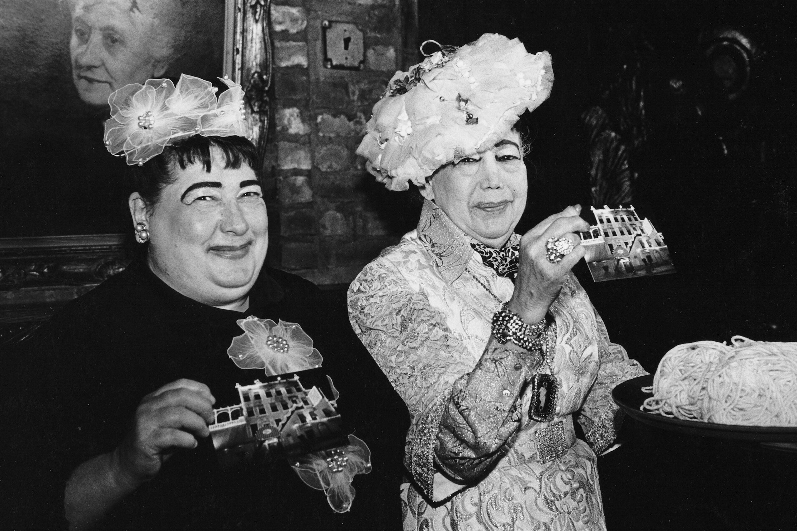 black and white photo of two women with fascinators 