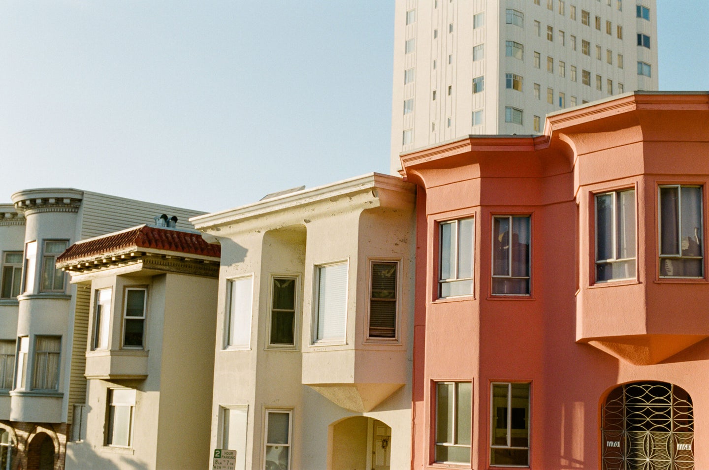 golden hour sunset hits yellow and red san francisco apartment buildings in russian hill