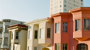 golden hour sunset hits yellow and red san francisco apartment buildings in russian hill