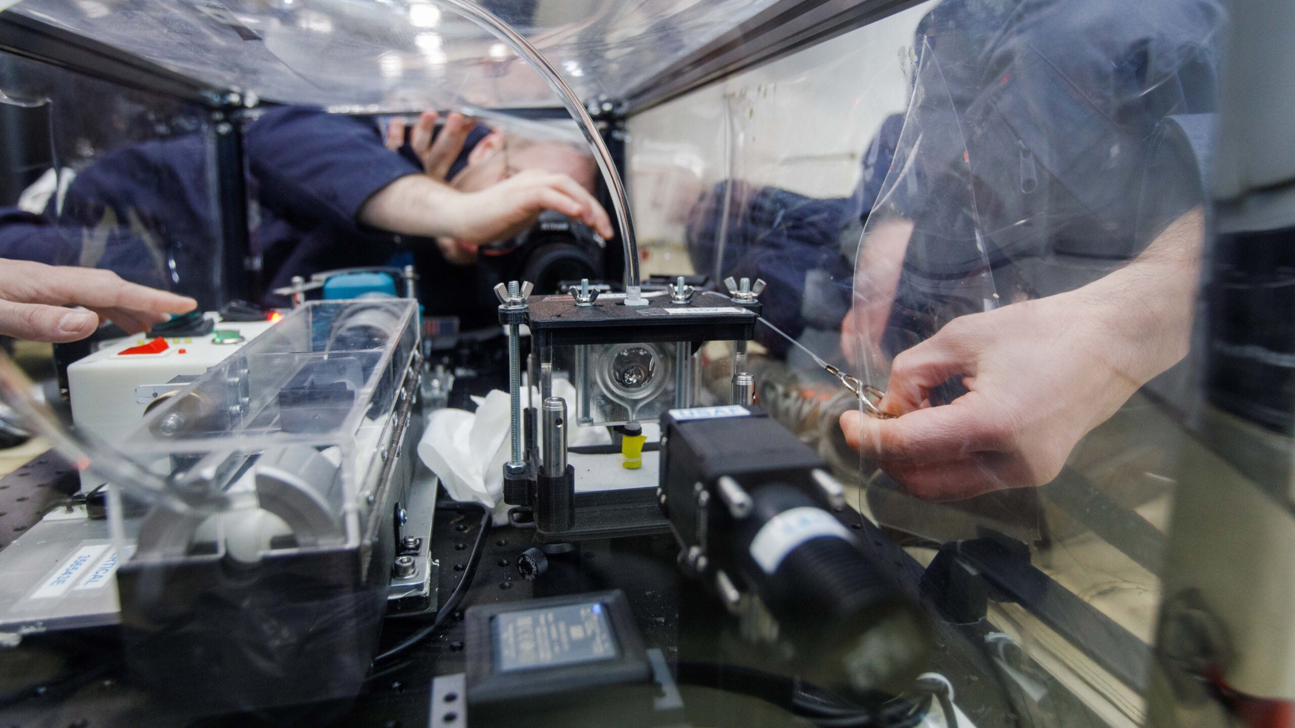FLUTE researchers capture data while they push synthetic oil into a circular frame (about the size of a dollar coin), momentarily forming a liquid lens during a 15 to 20-second period of microgravity on a ZeroG parabolic flight.