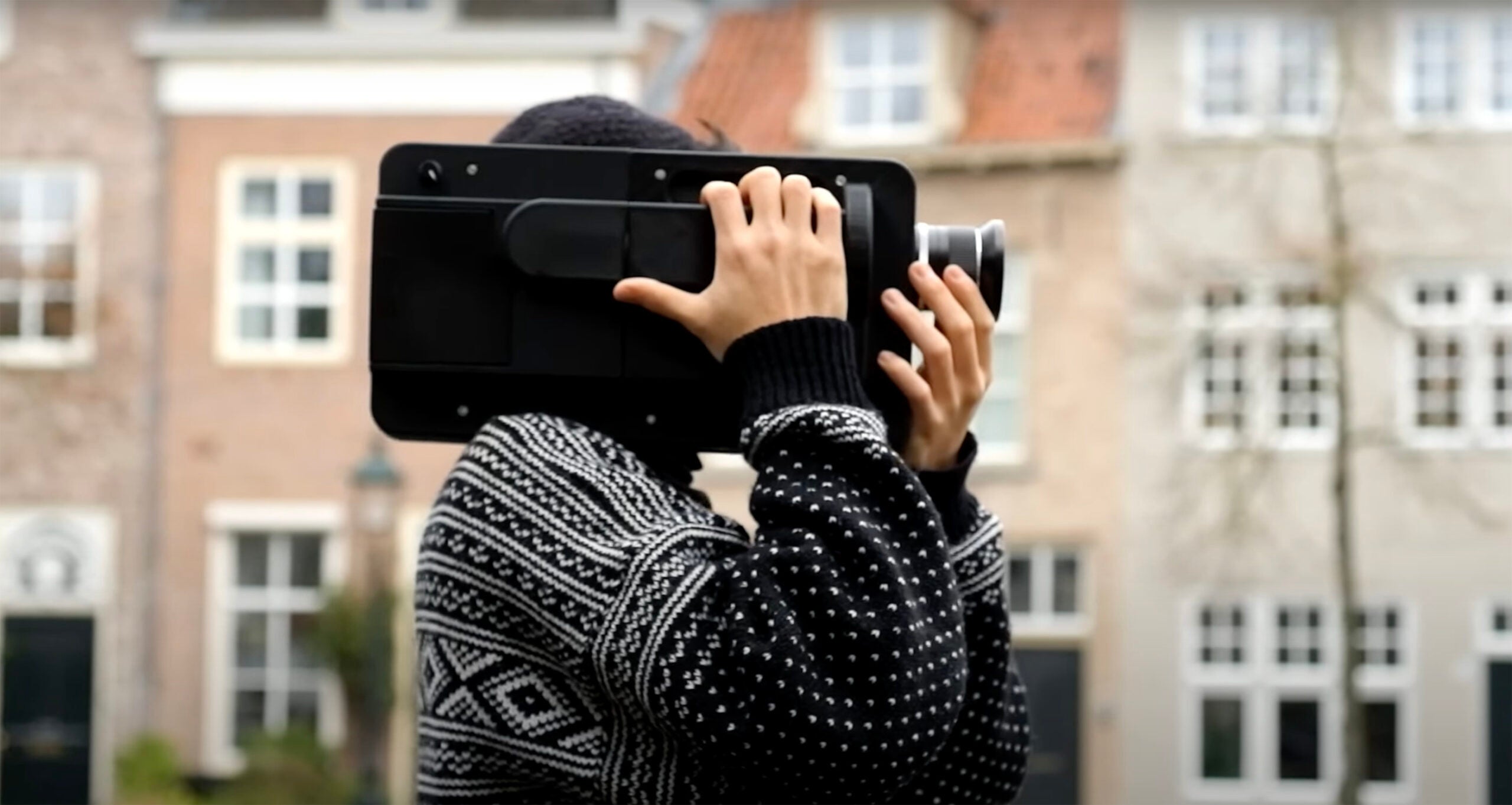 A 3D-printed 35mm movie camera on a man's shoulders.