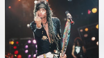 Steven Tyler of Aerosmith gives the finger as he poses with his microphone