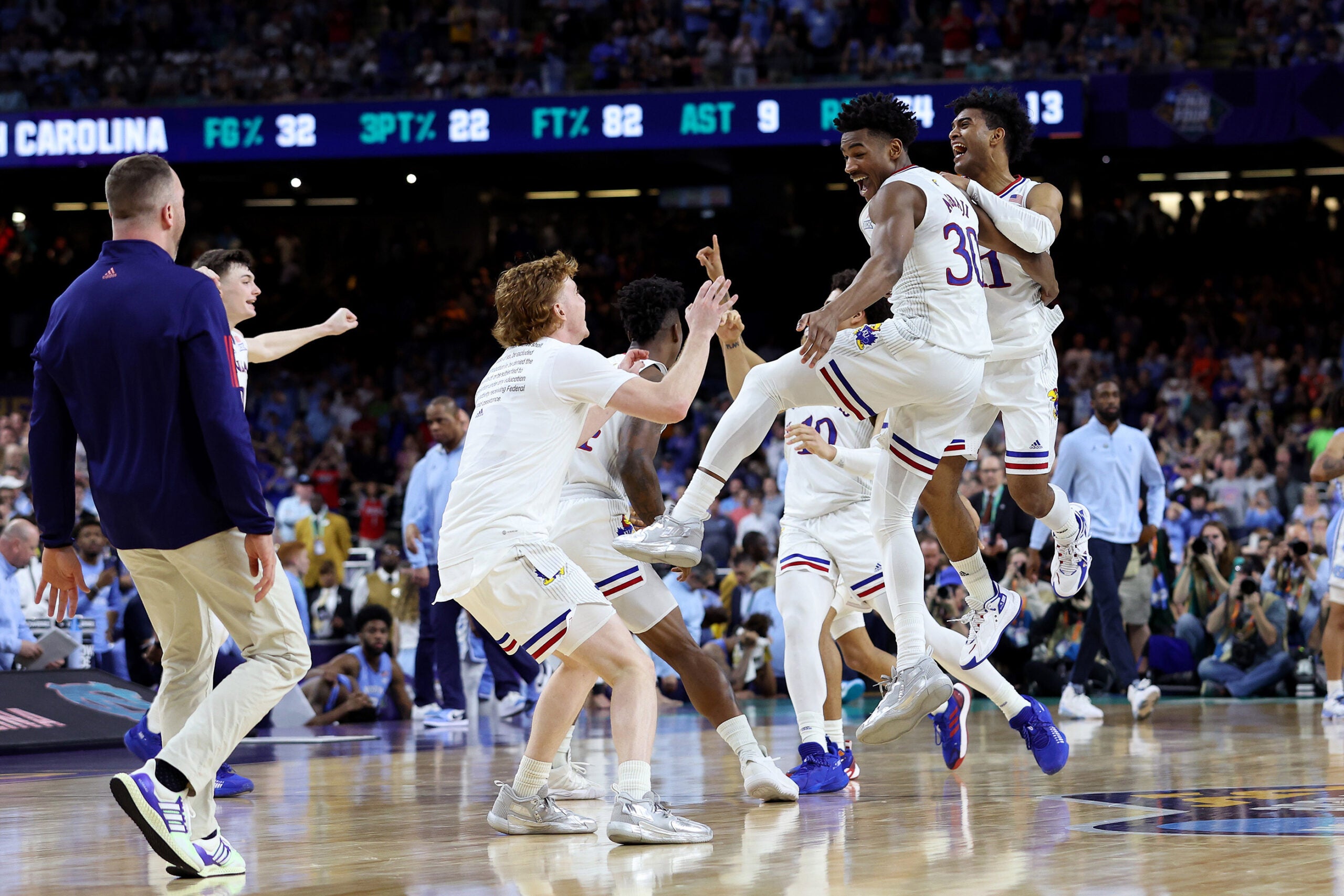 Kansas Jayhawks players celebrate after defeating the North Carolina Tar Heels 72-69 during the 2022 NCAA Men's Basketball Tournament National Championship.