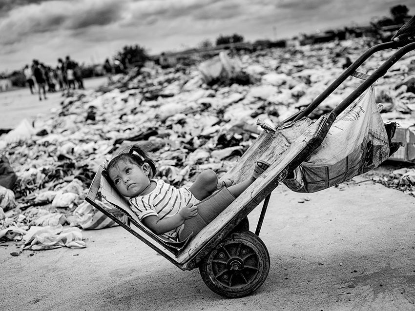 a young girl pulled in a wheelbarrow in Venezuela amid the financial collapse 
