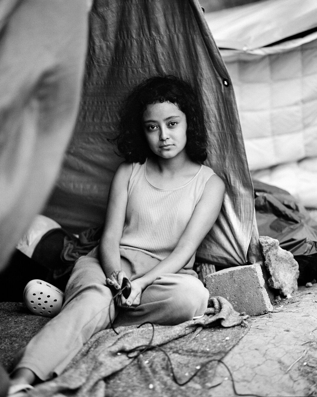 A black and white portrait of a migrant girl on the US Mexico border