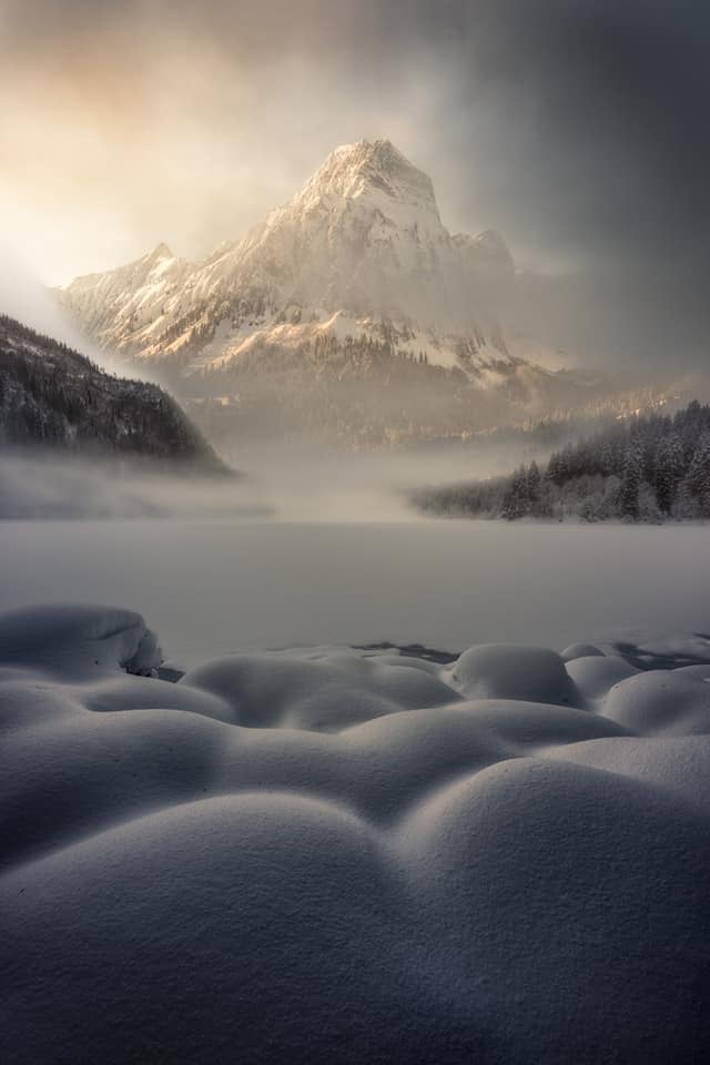 swiss alps at under the fog in the winter with snow
