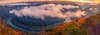 panorama of a valley at sunset. soft clouds blanket the trees