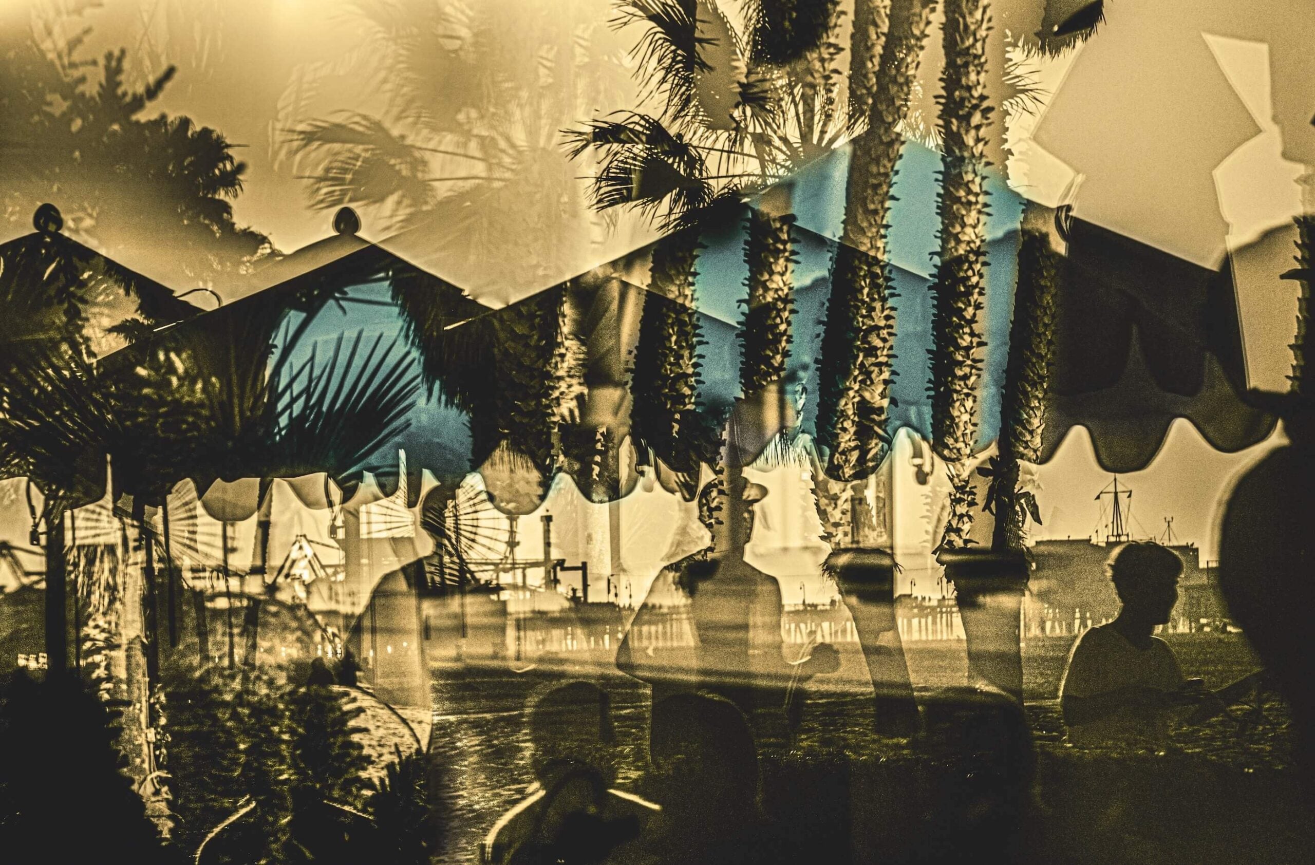multiple exposure photograph of palm trees and blue beach umbrellas