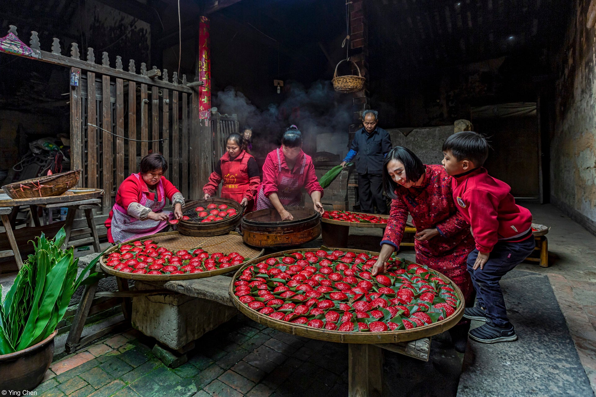 a family folds red dumplings