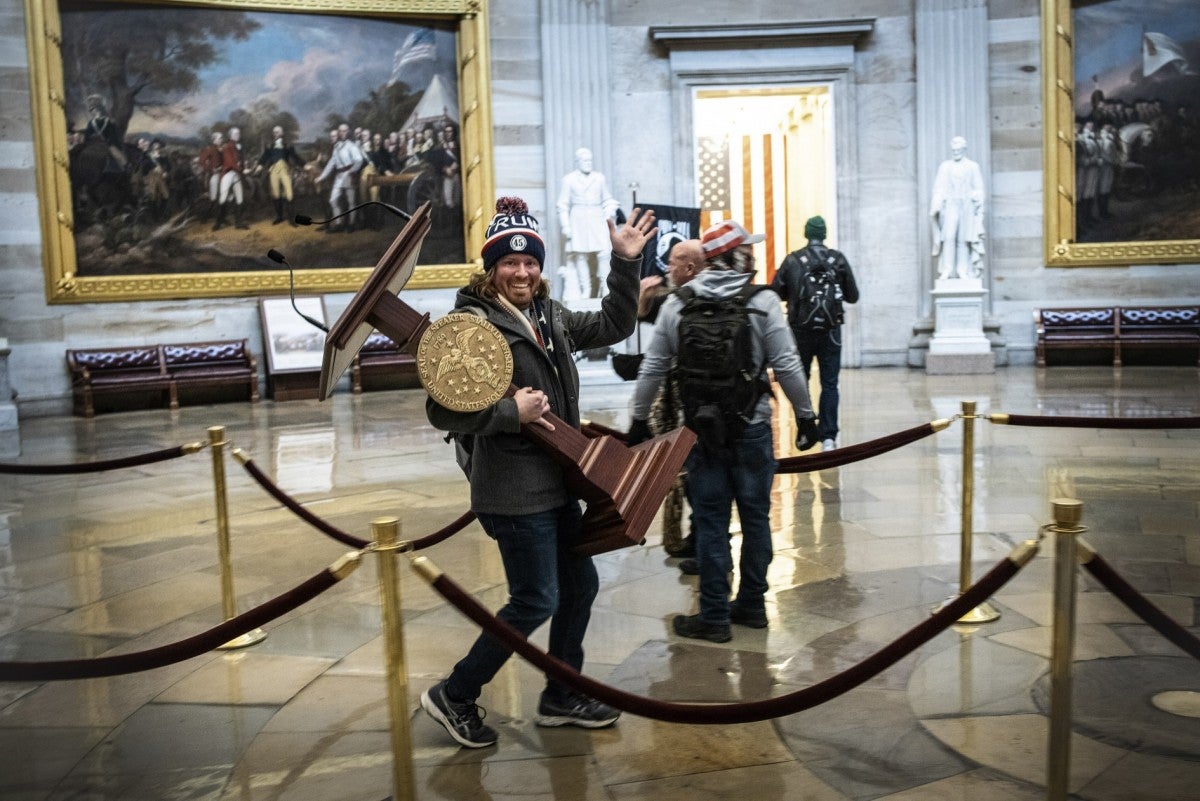 Adam Johnson, a supporter of U.S. President Donald Trump, carries a lectern belonging to Speaker of the House Nancy Pelosi through the Rotunda of the U.S. Capitol after members of a mob broke into the Capitol on January 6, 2021 in Washington, DC. 