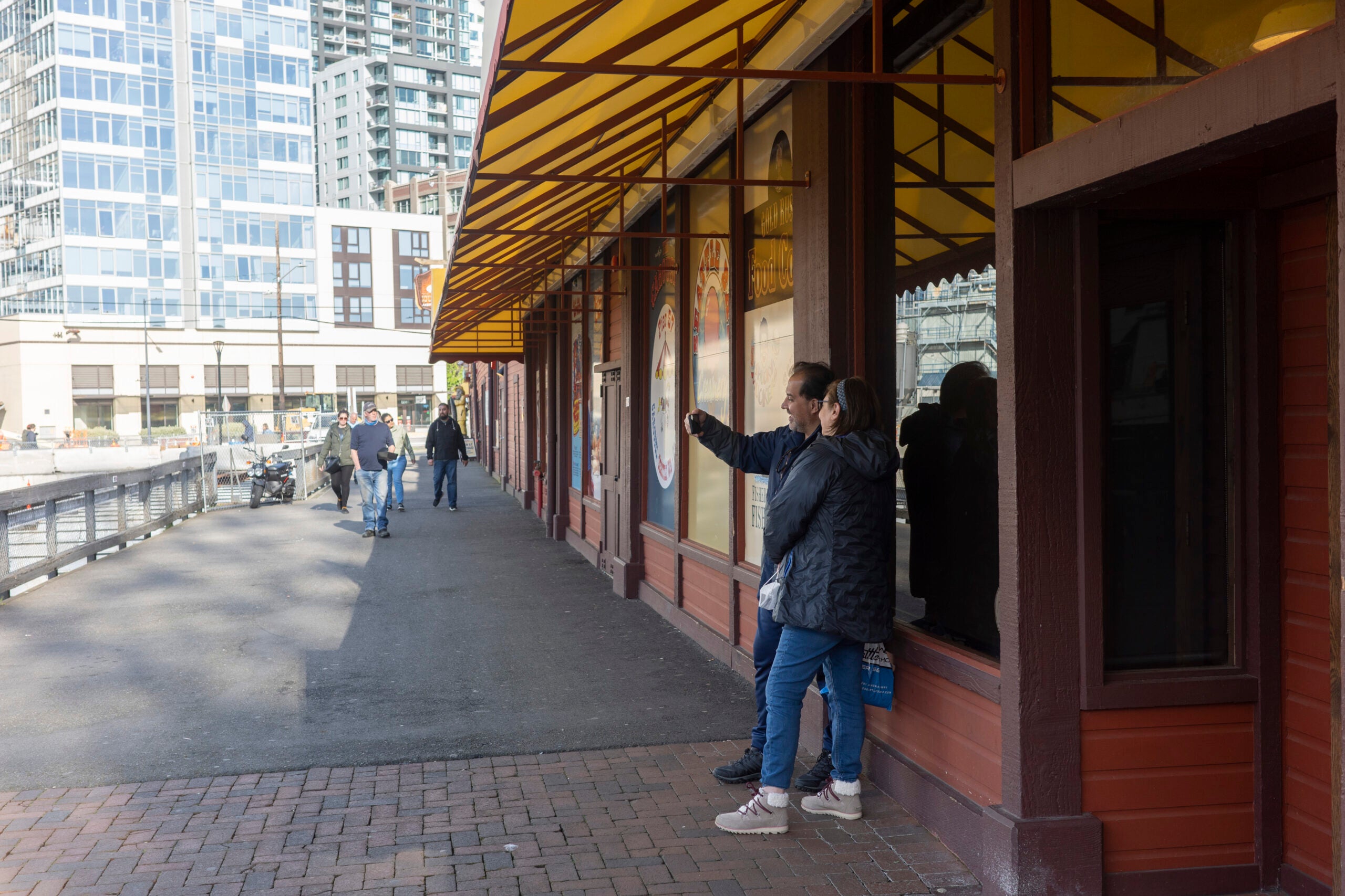 A street photo of two people under a building awning.