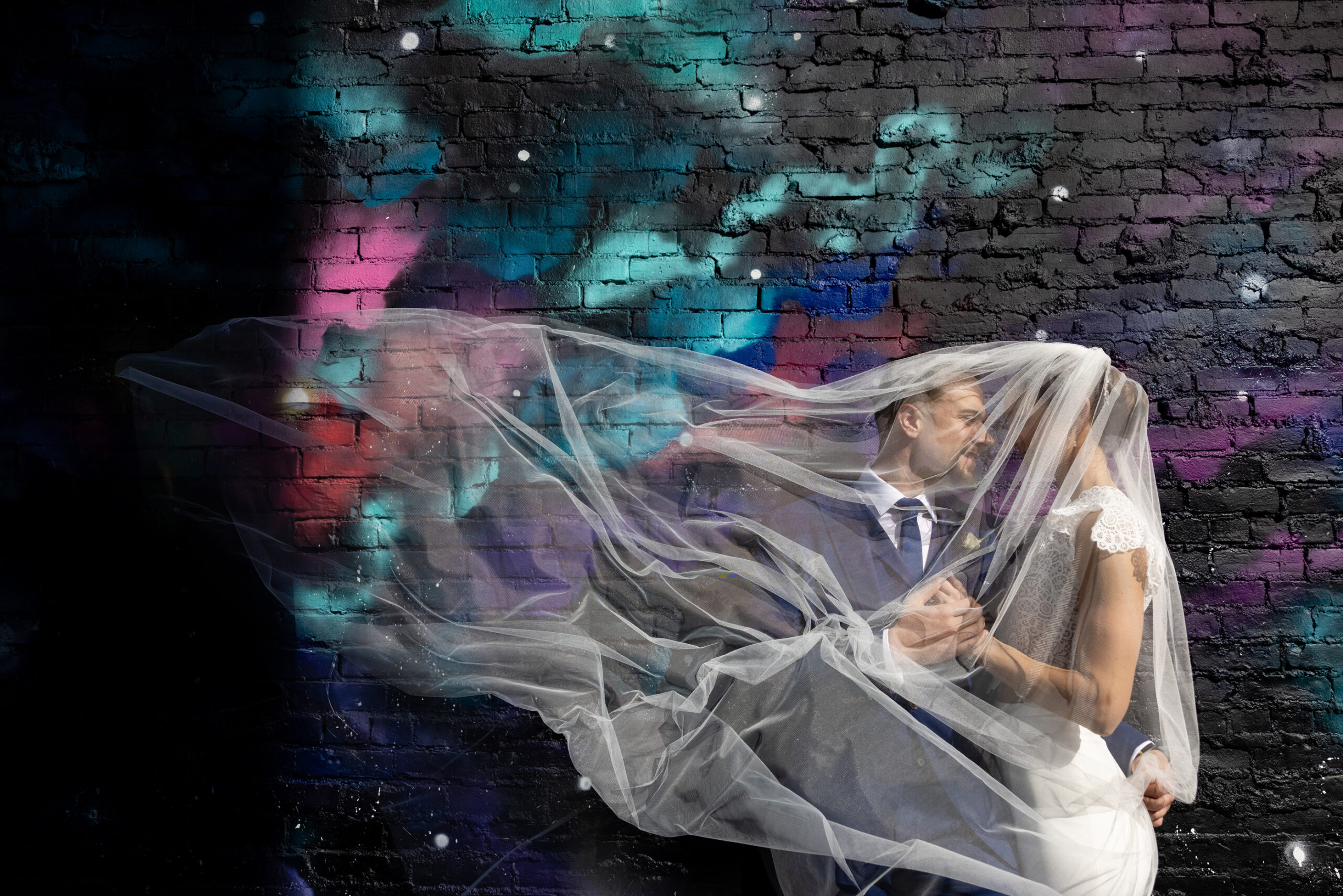 Bride and groom in front of a cool mural.