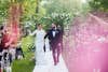 Bride and groom walk down the aisle with confetti.