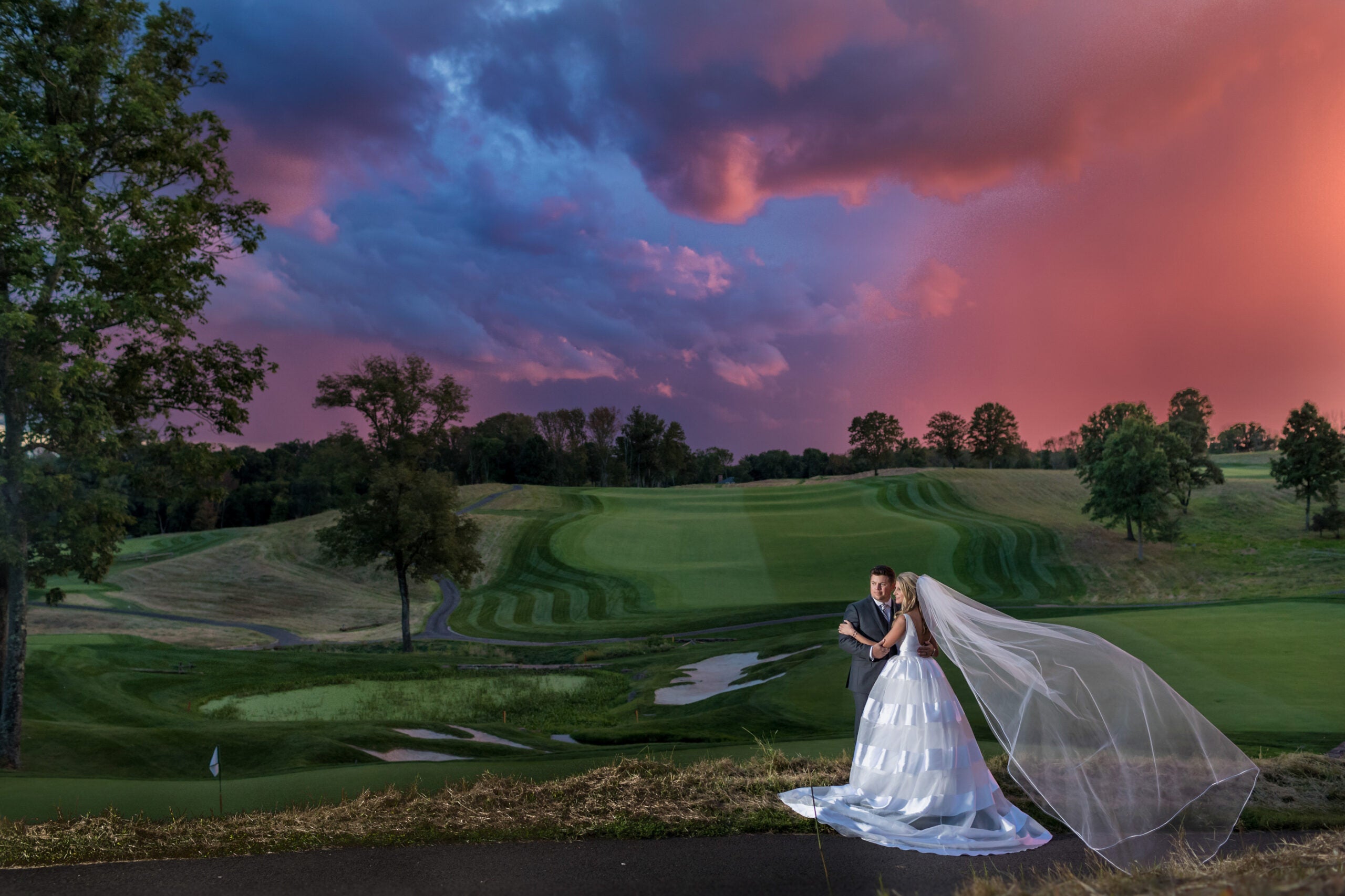 A bride and groom with a stunning sunset behind them.