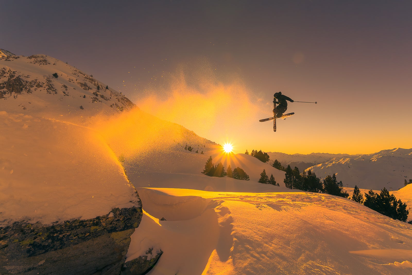 skier at sunset jumping off slope