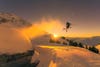 skier at sunset jumping off slope