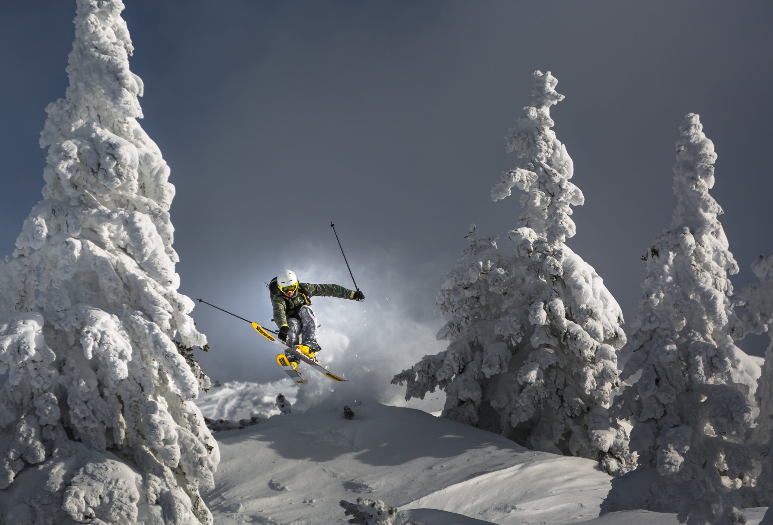 skier leaves cloud of snow 