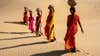 women carrying water across the desert