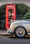 vintage car in front of red telephone booth