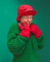 woman wearing green sweater, red gloves and hat