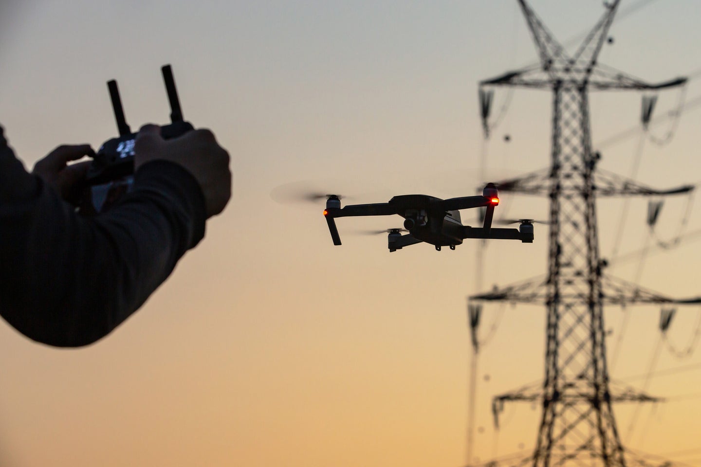 Flying a drone at sunset with power lines in the distance