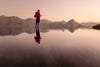 Person dressed in red moves across a dreamy landscape