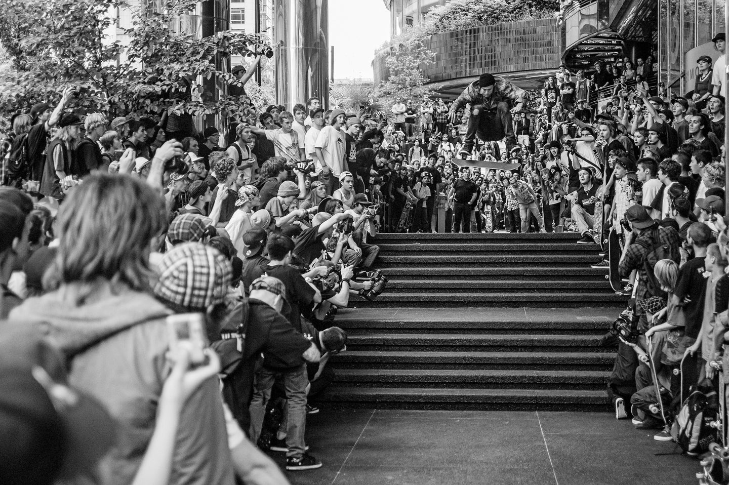 Andrew Reynolds frontside flips a hefty double set of stairs in front of a crowd