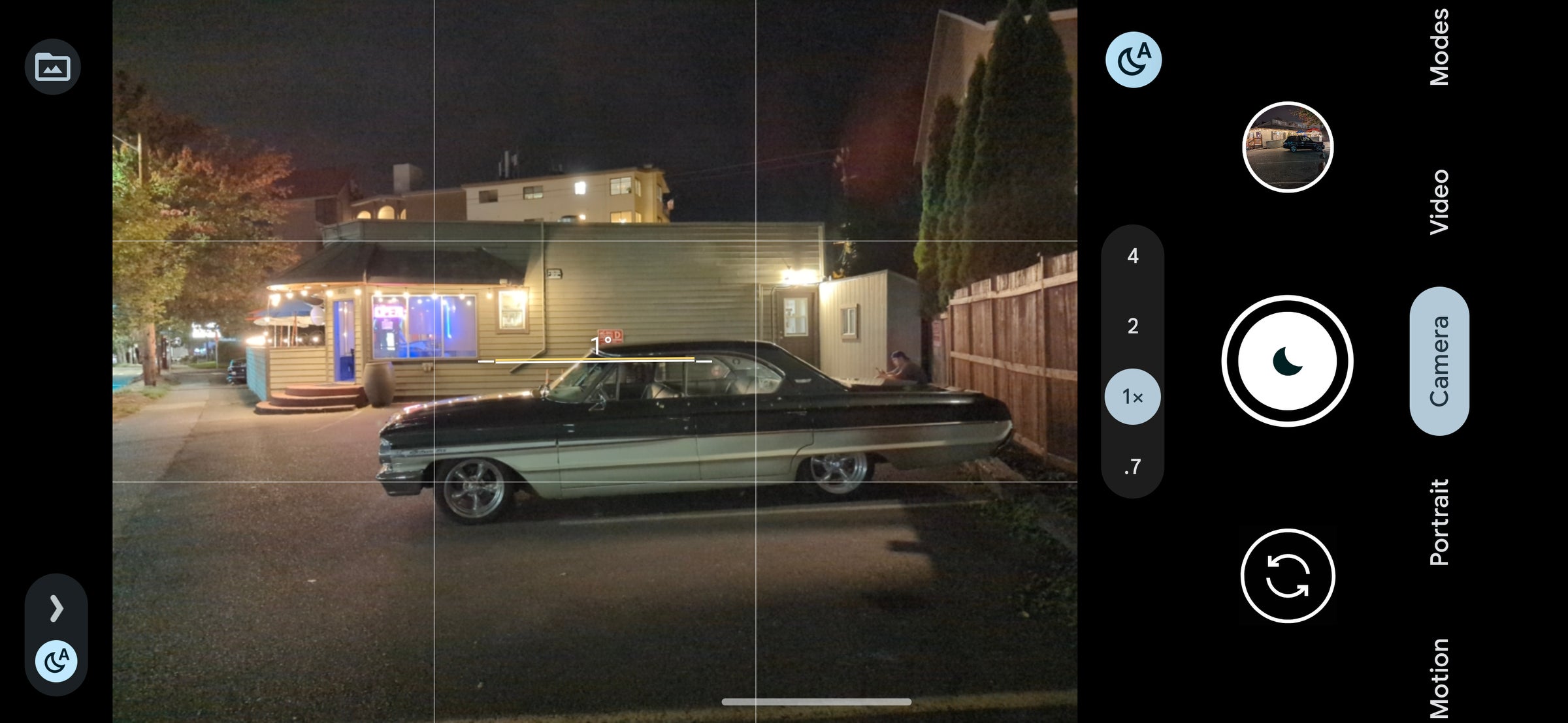 Une scène de nuit faiblement éclairée avec une vieille voiture.