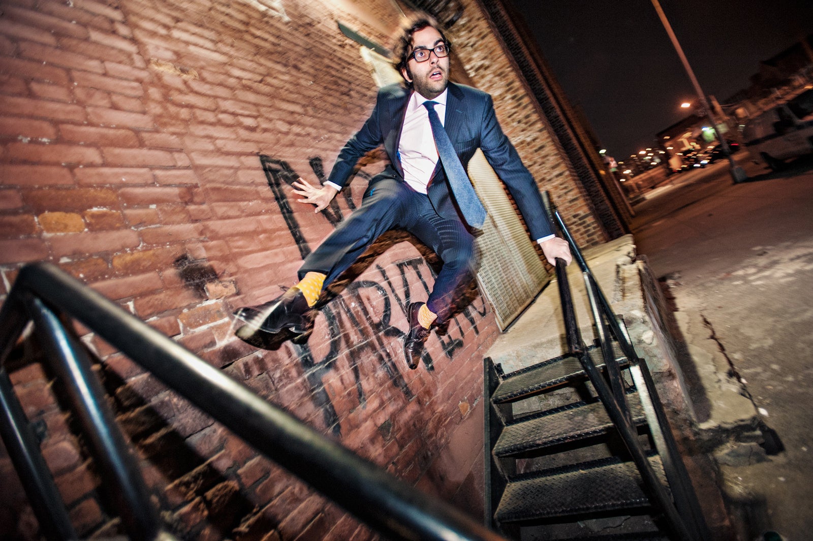 A man in a suit jumping off a wall 