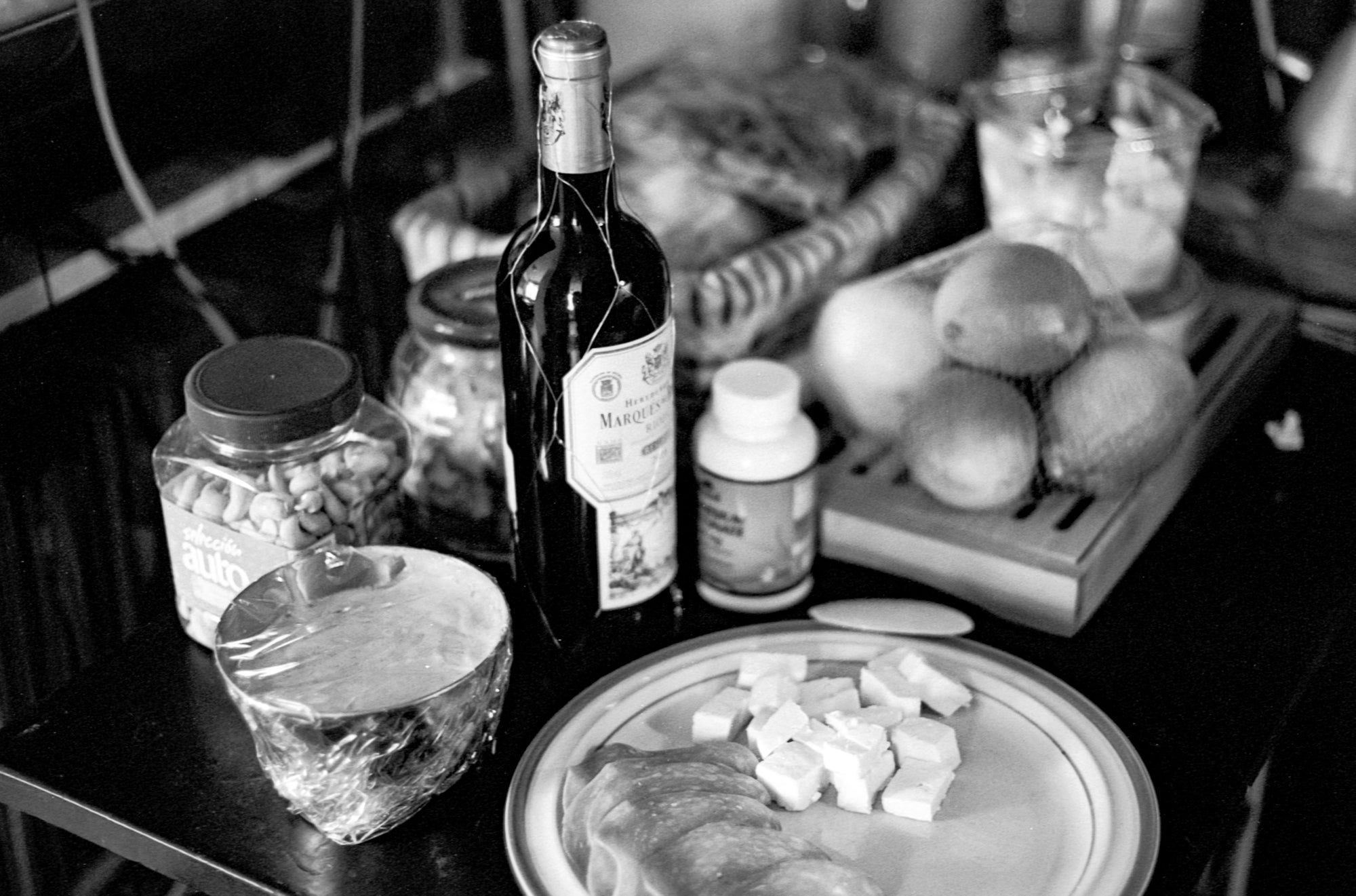 A table with dishes and bottles in B&W.