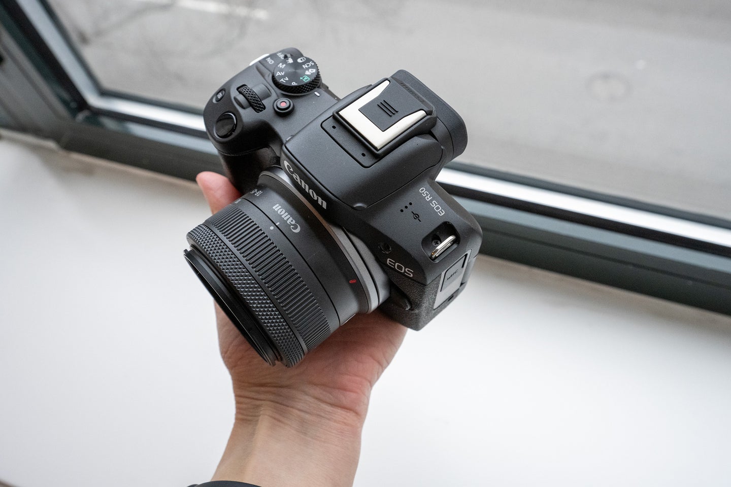 Canon R50 in a hand