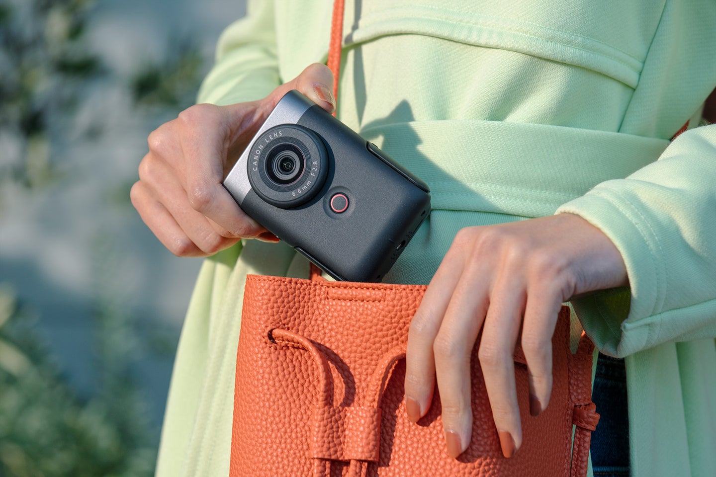 Woman holding a Canon PowerShot V10 camera