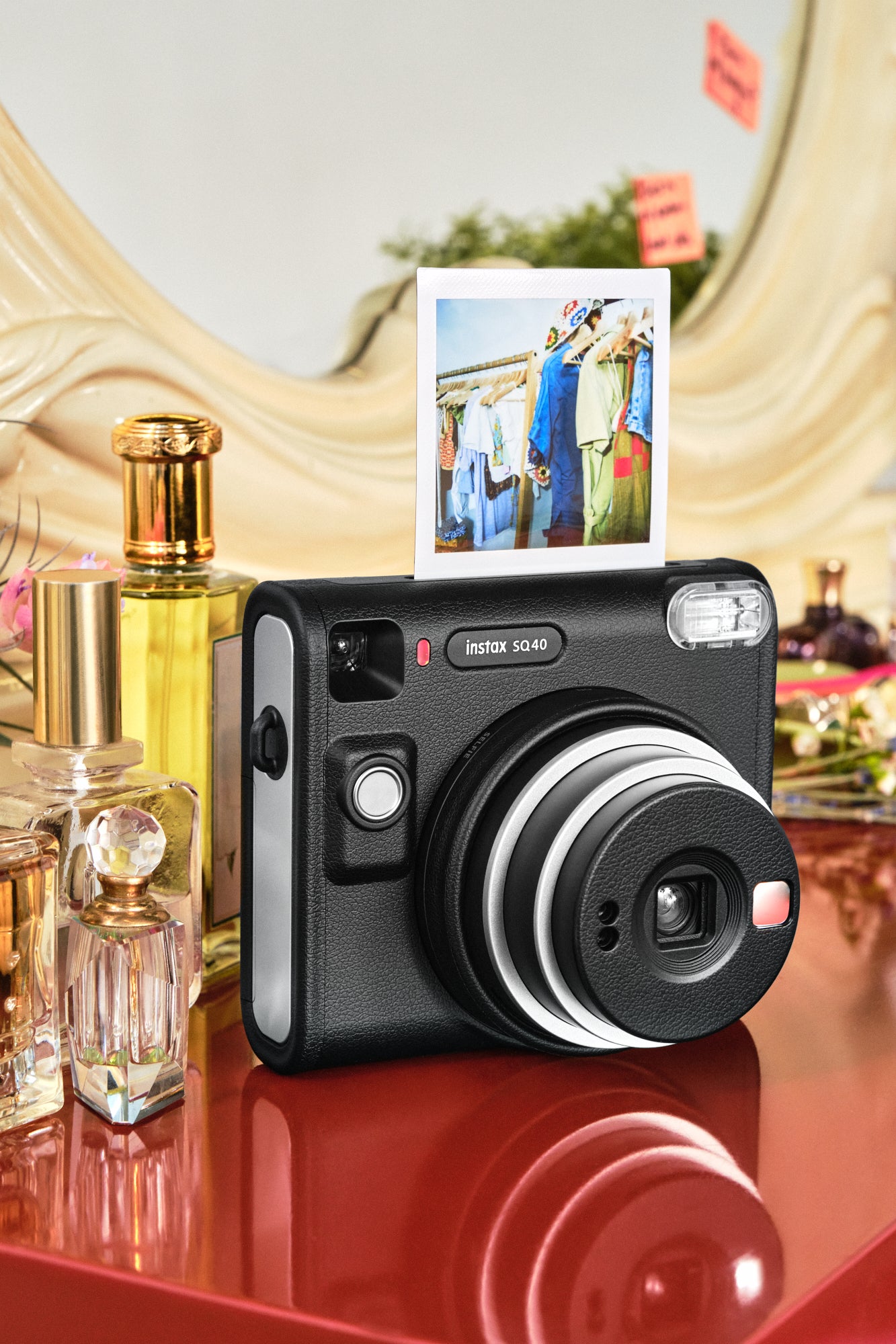 Instax SQ40 film camera next to perfume bottles