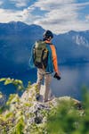 A climber wears a Lowepro PhotoSpot X while looking over a cliff.