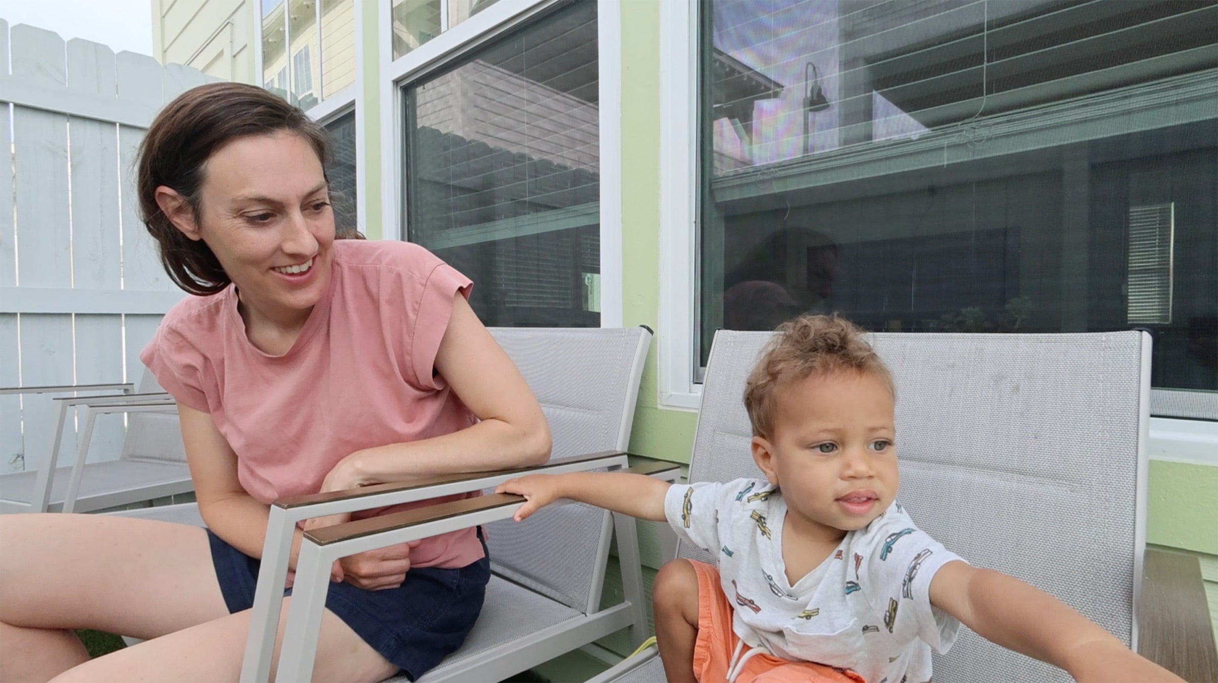 A screenshot of a video of a woman and her son on patio chairs, taken on the Canon PowerShot V10 vlogging camera