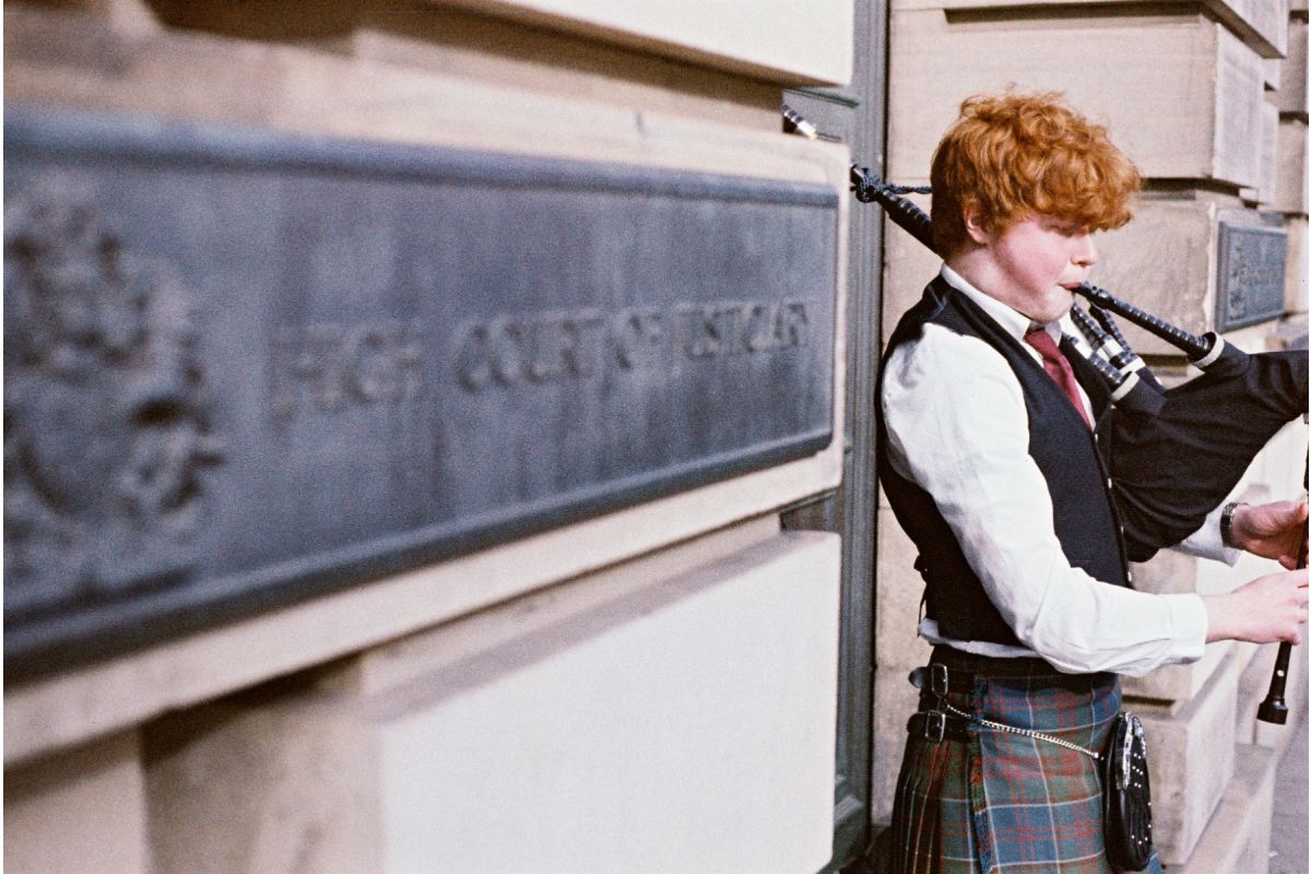 A lomography Color 92 film example of a boy playing bagpipes.