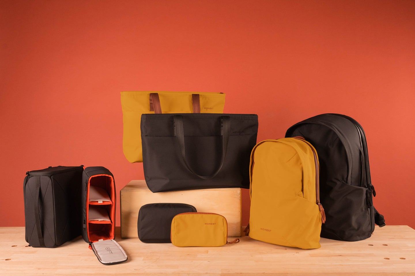The Moment Everything Bag lineup against a red-orange background