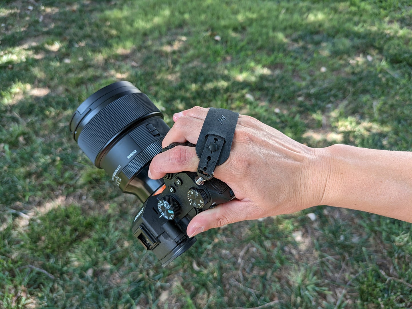 Peak Design Micro Clutch in a hand with the Sony a7 III camera