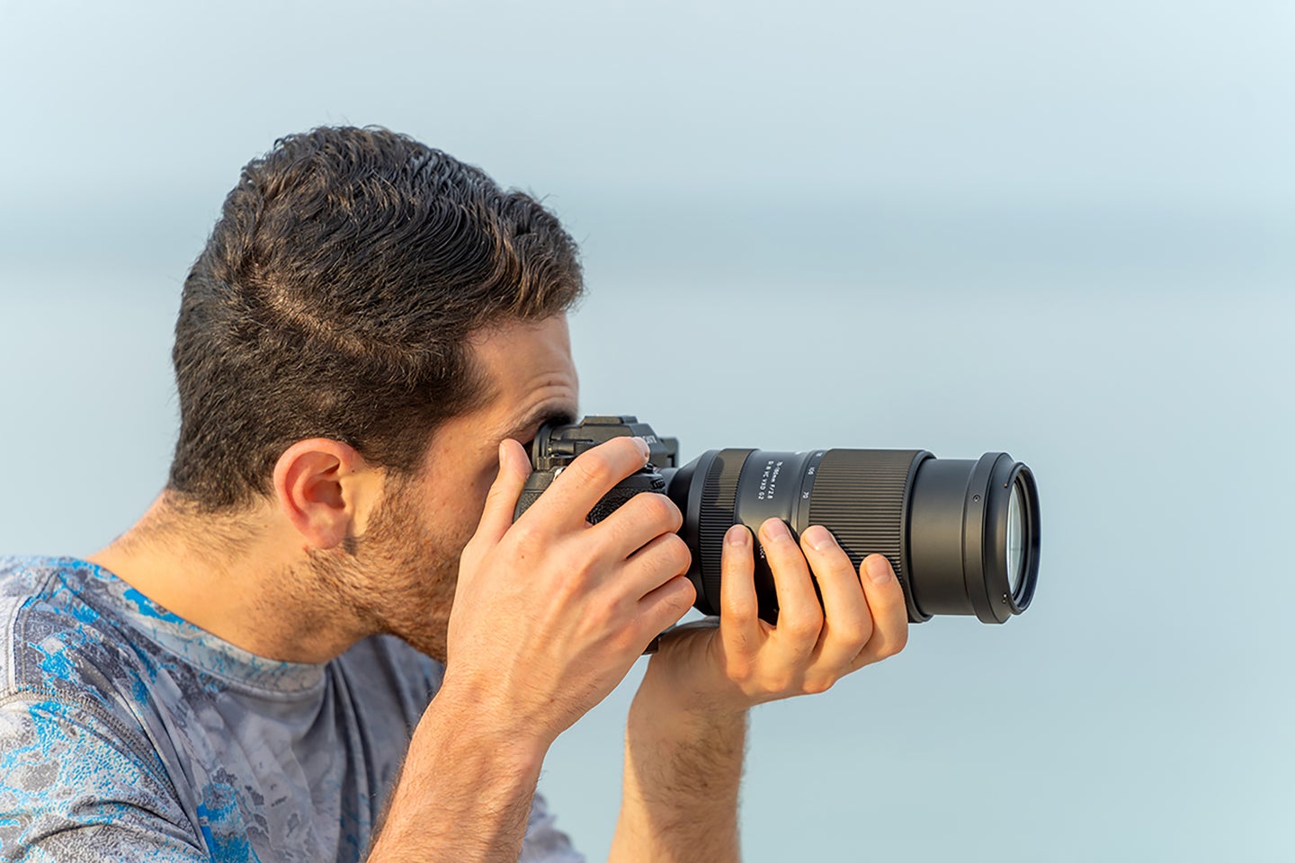 A man holding Tamron's 70-180mm G2 lens