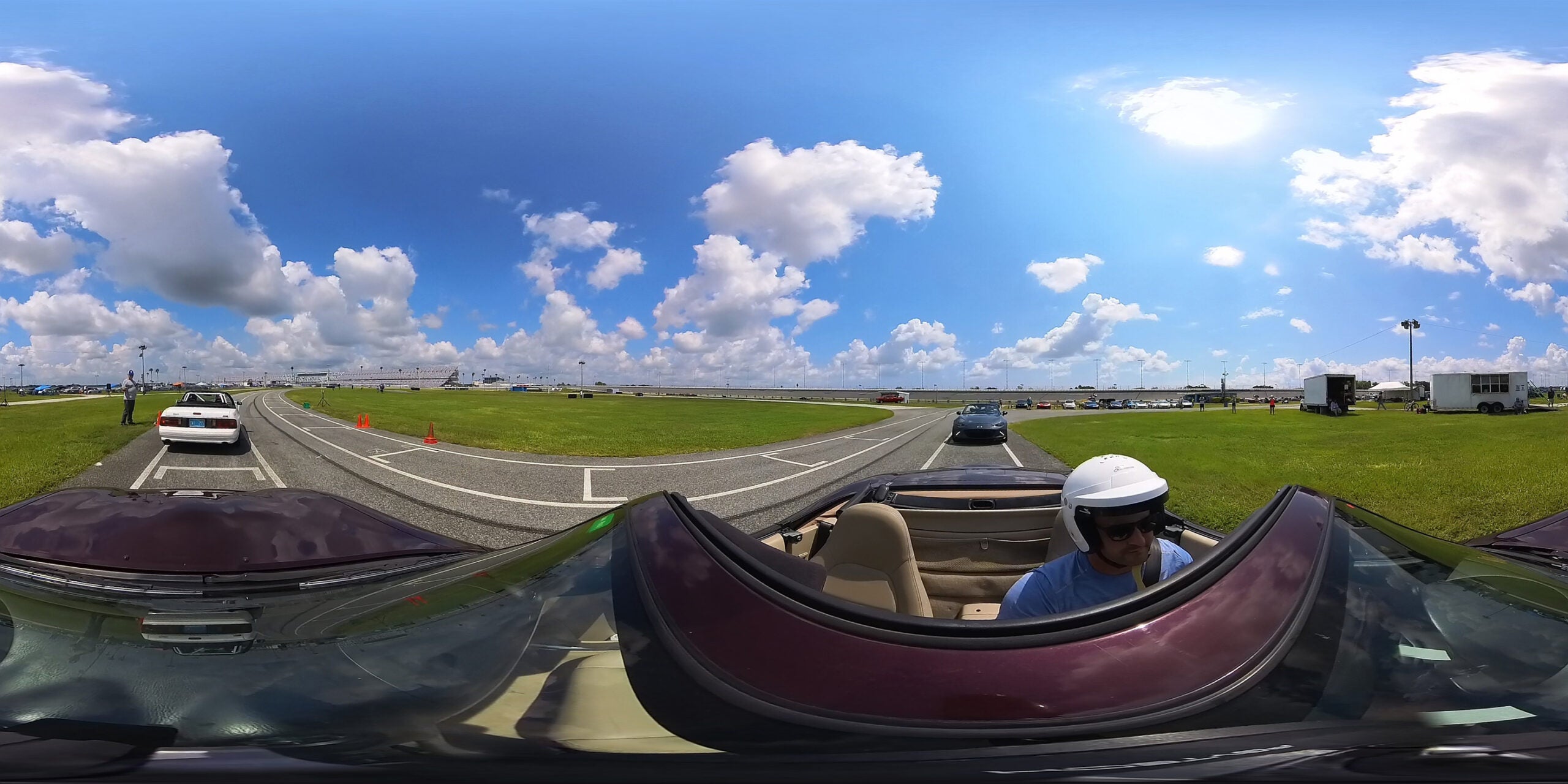 A screen grab of a 360 video showing a man in a Miata convertible at an autocross track.