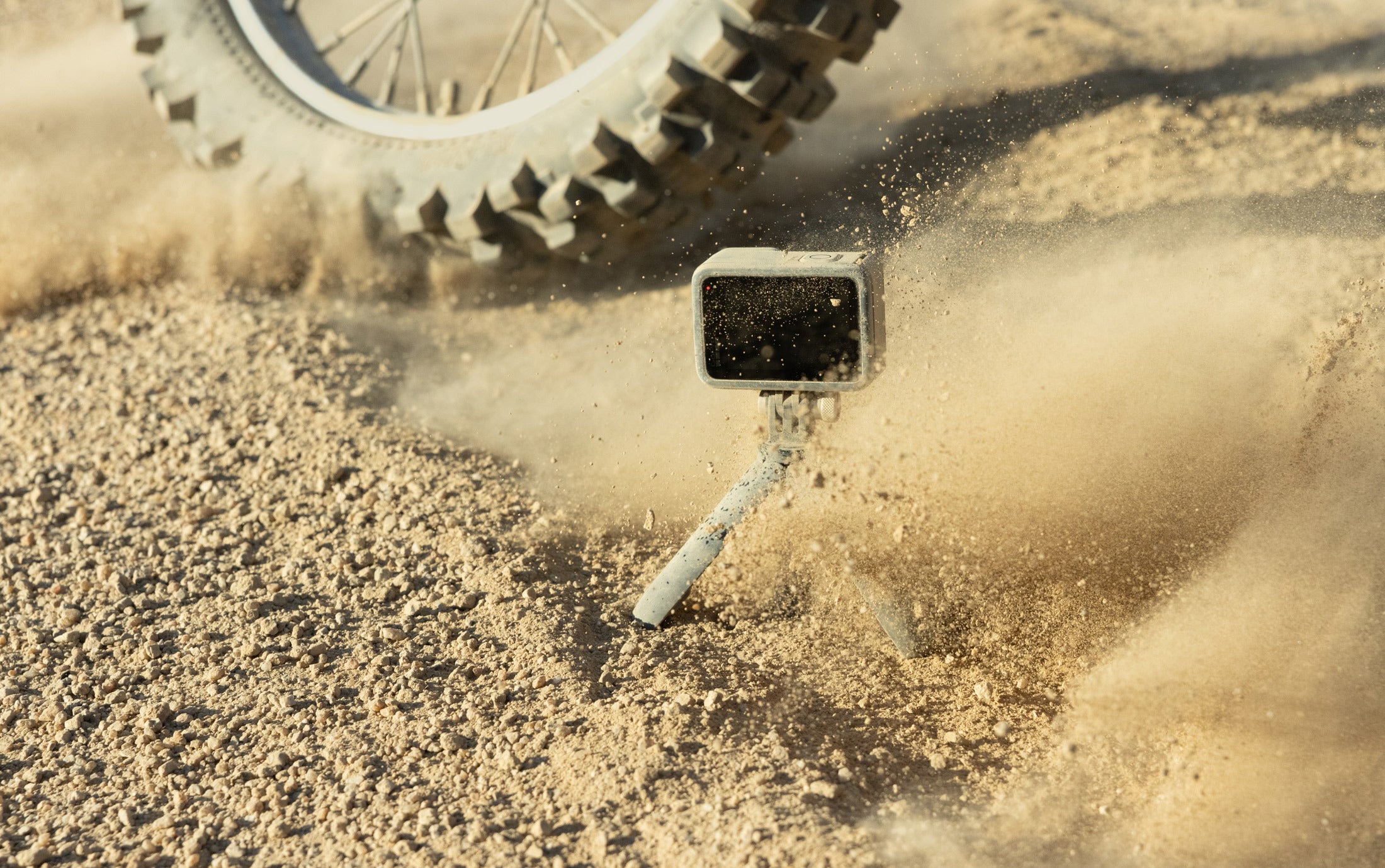 The GoPro Hero12 Black getting sprayed in dirt by a dirt bike